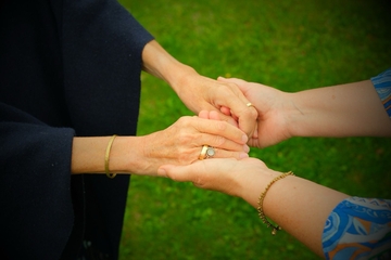 Verbundene Hände als Symbol für Freundschaft und Nähe, eingefangen durch emotionale Fotografie bei einer persönlichen Zeremonie
