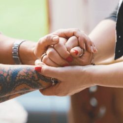 Zwei Menschen stehen sich gegenüber und halten sich an den Händen – – Essence of Love begleitet echte Begegnungen voller Gefühl