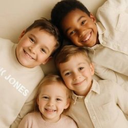 Kinder liegen nebeneinander und lachen – Essence of Love schafft unvergessliche Erinnerungen durch natürliche Familienfotografie