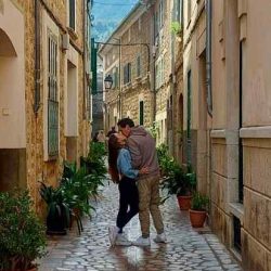 Junges Paar küsst sich verliebt in einer mediterranen Straße – ein romantischer Moment voller Liebe und Nähe, festgehalten in einem authentischen Paarfotoshooting