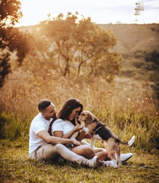 Ein Liebespaar sitzt in der Natur mit einem Hund - Ein liebevoller Augenblick festgehalten von Essence of Love in authentischer Paarfotografie