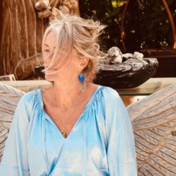 Frau posiert vor dekorativen Holzflügeln – ein authentischer Moment eines natürlichen Fotoshootings in der Natur